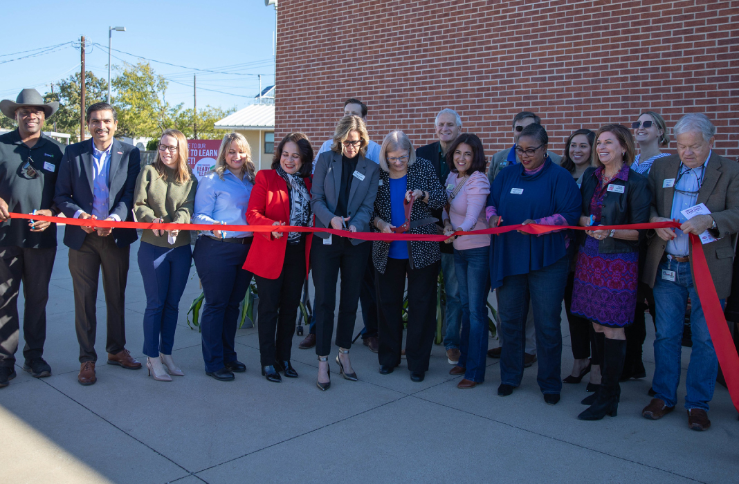Staff and partners cutting a ribbon